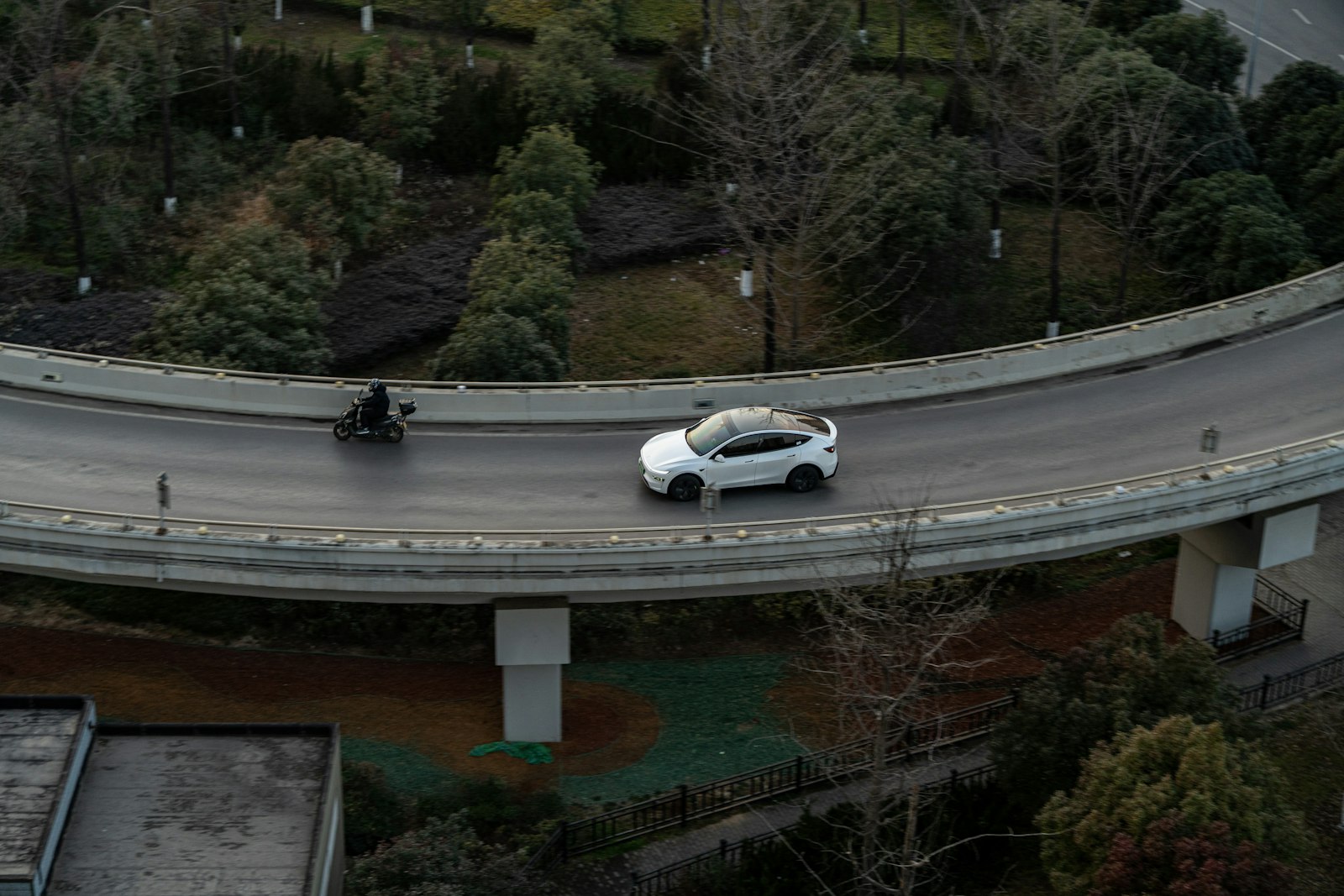 Aerial view of a white Tesla Model Y on a winding road